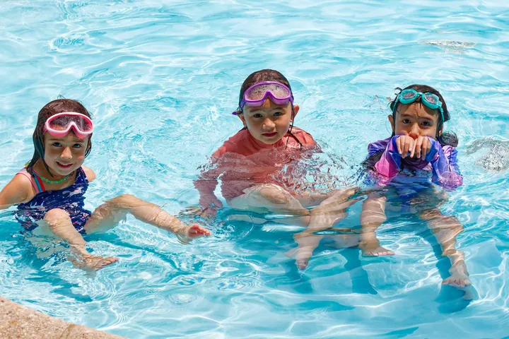 Three girls in goggles in the outdoor pool