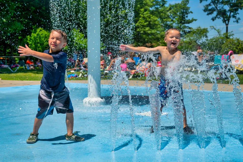 Two boys playing in the fountains of the splash park