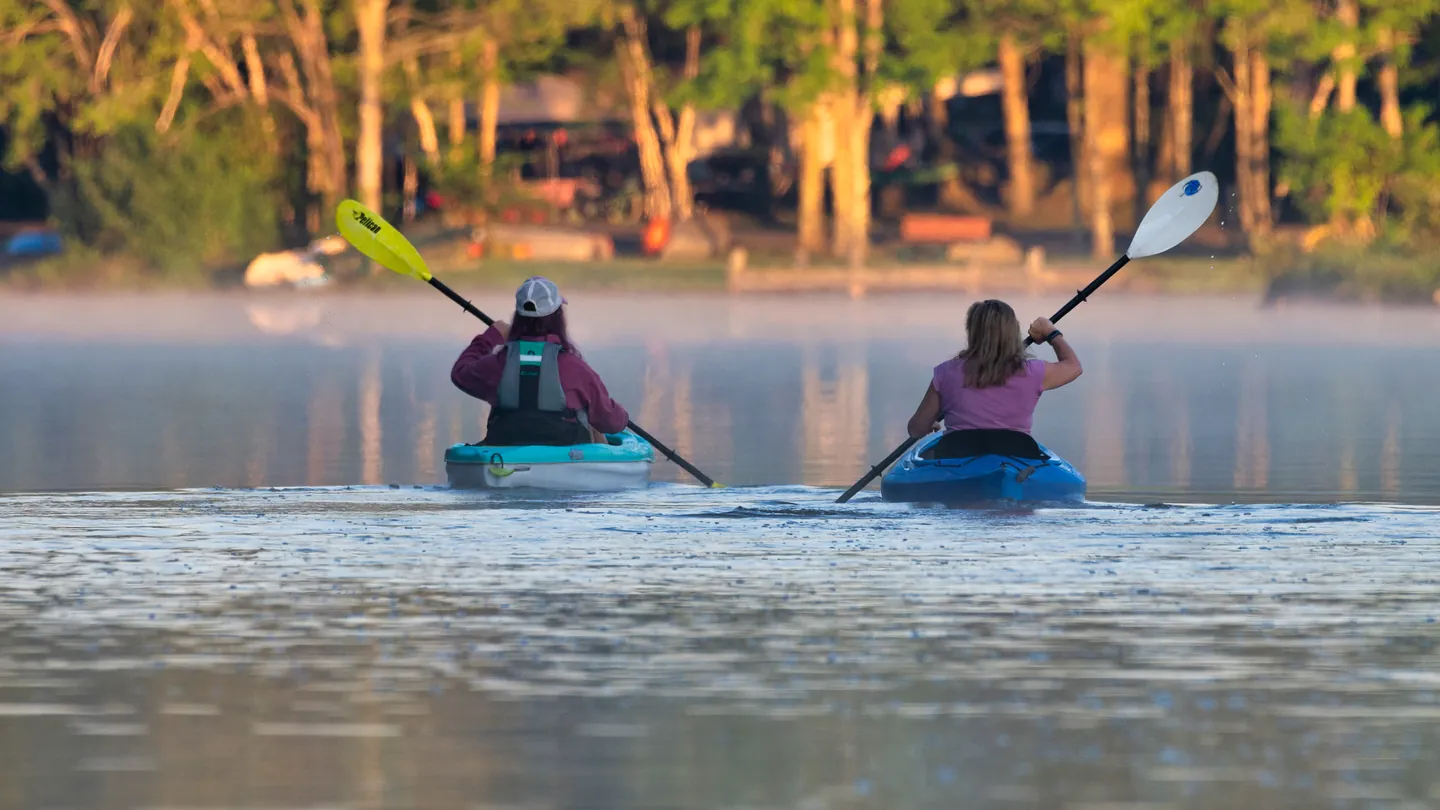 Two kayakers in the morning mist