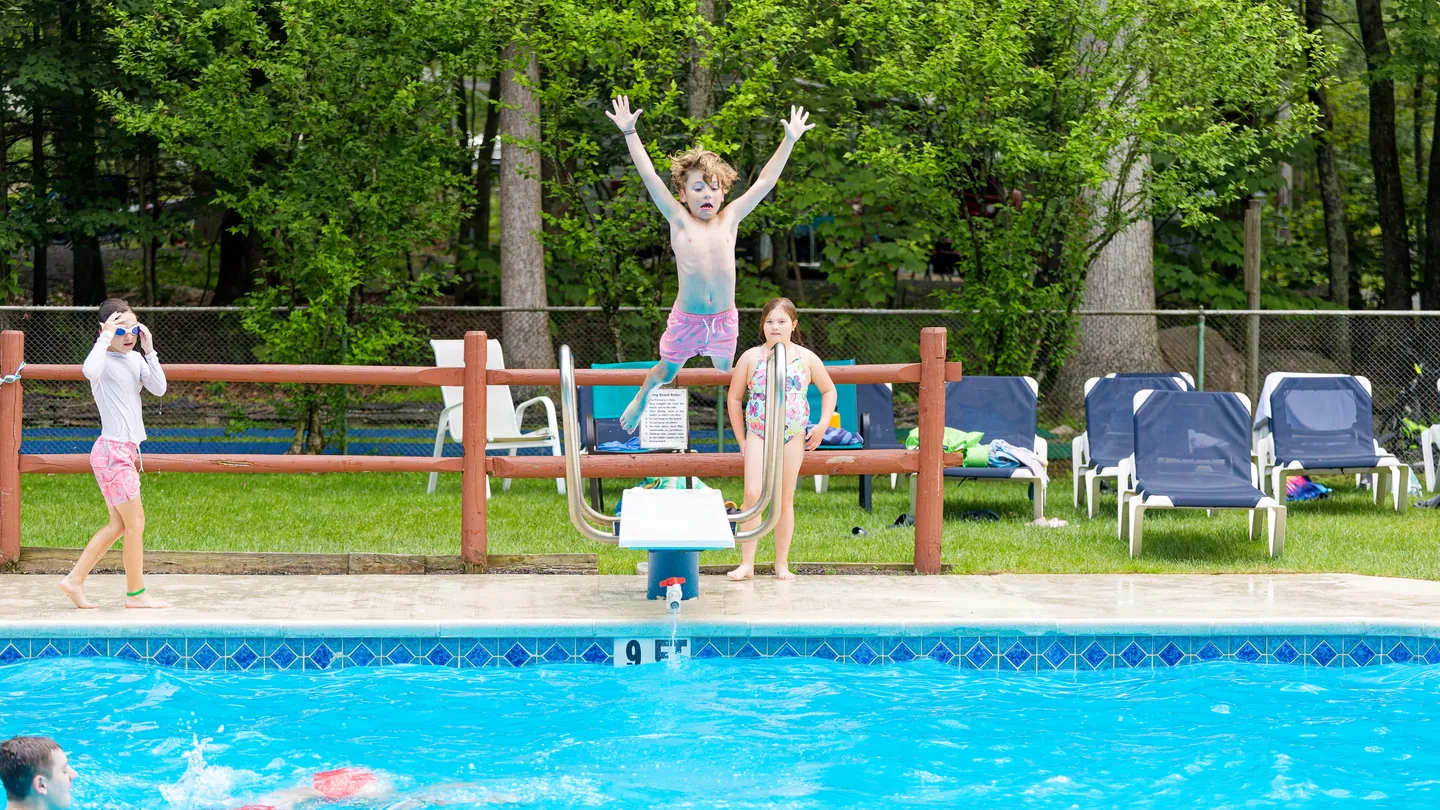 A jump off the diving board into the outdoor pool